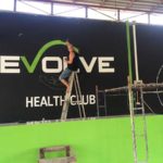 painting Evolve health club sign